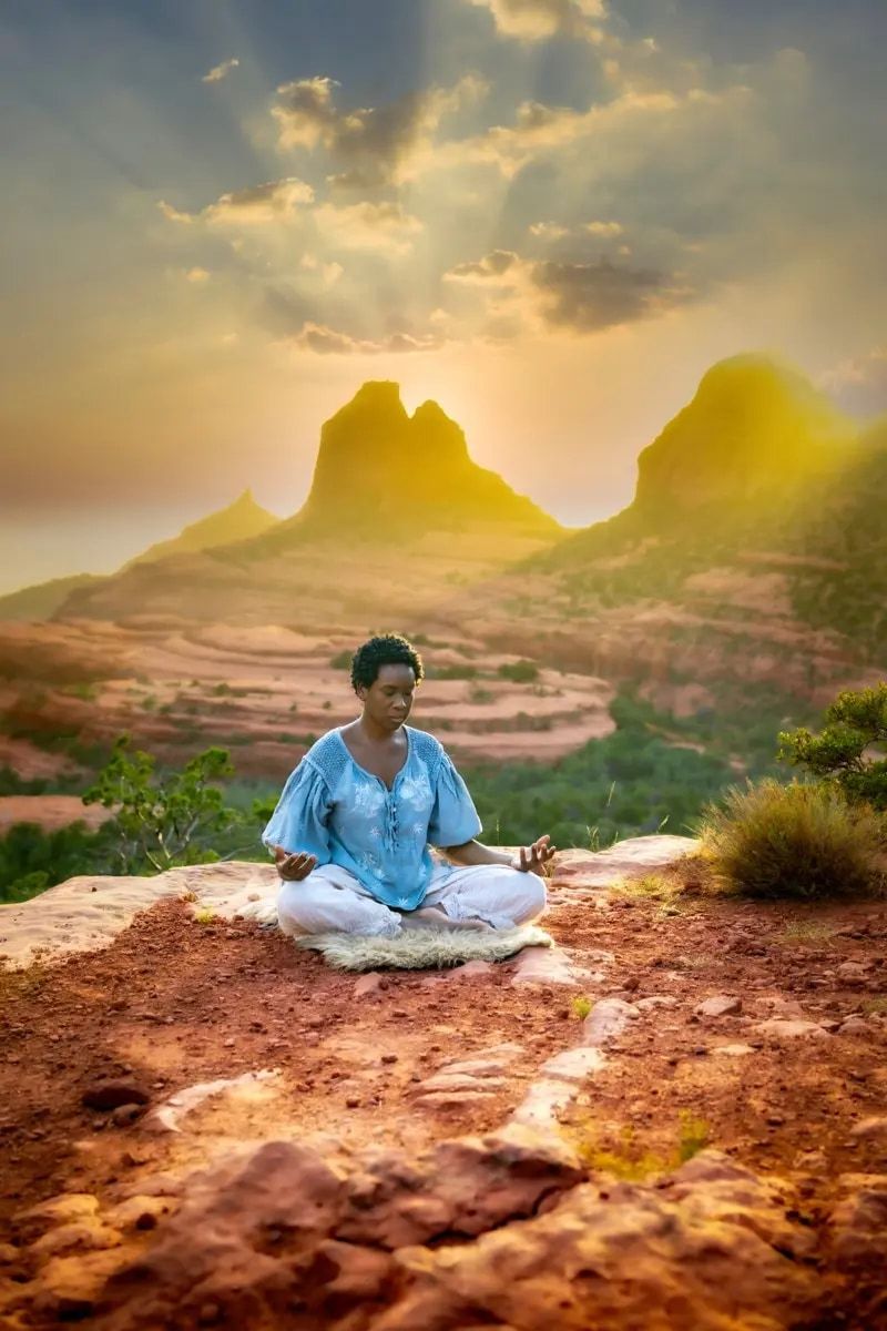 Yolessa seated in meditation on red rock at sunrise in Sedona